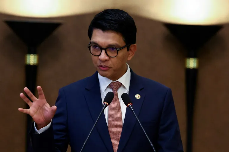 Andry Rajoelina speaking in front of two microphones, wearing a blue suit and glasses, file photo