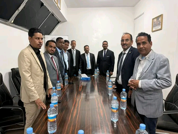 Two delegations standing around a meeting table