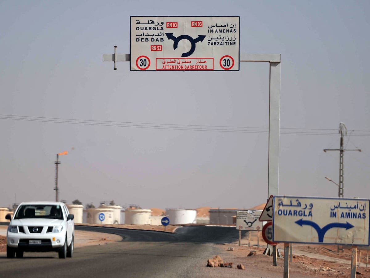 Road signs in Arabic and French pointing to Debdeb, Ouargla and In Amenas, with a vehicle on the road, file photo