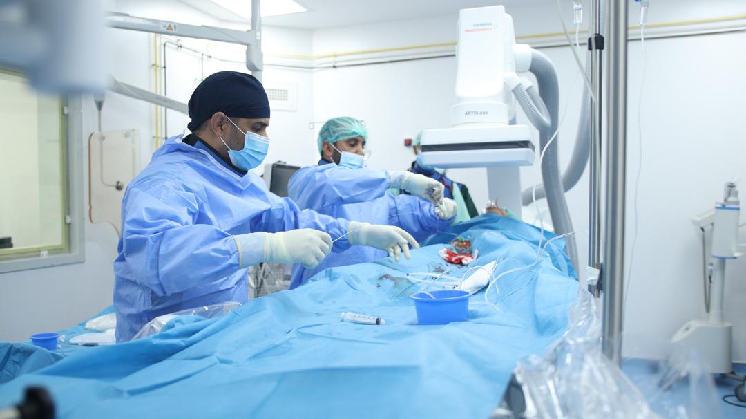 Doctors perform a procedure in a catheterisation room