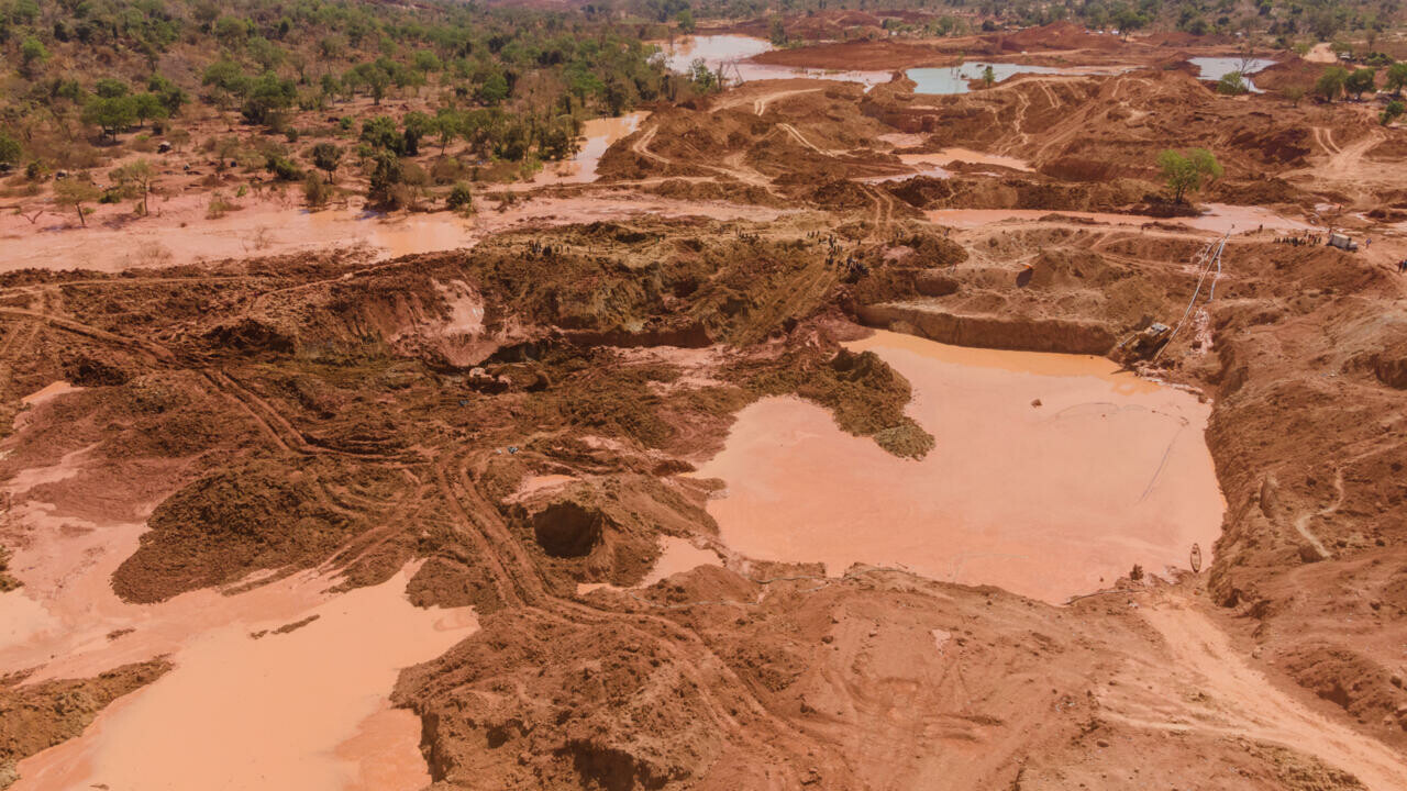Aerial view of a gold extraction site with pits and muddy pools on red earth, file photo