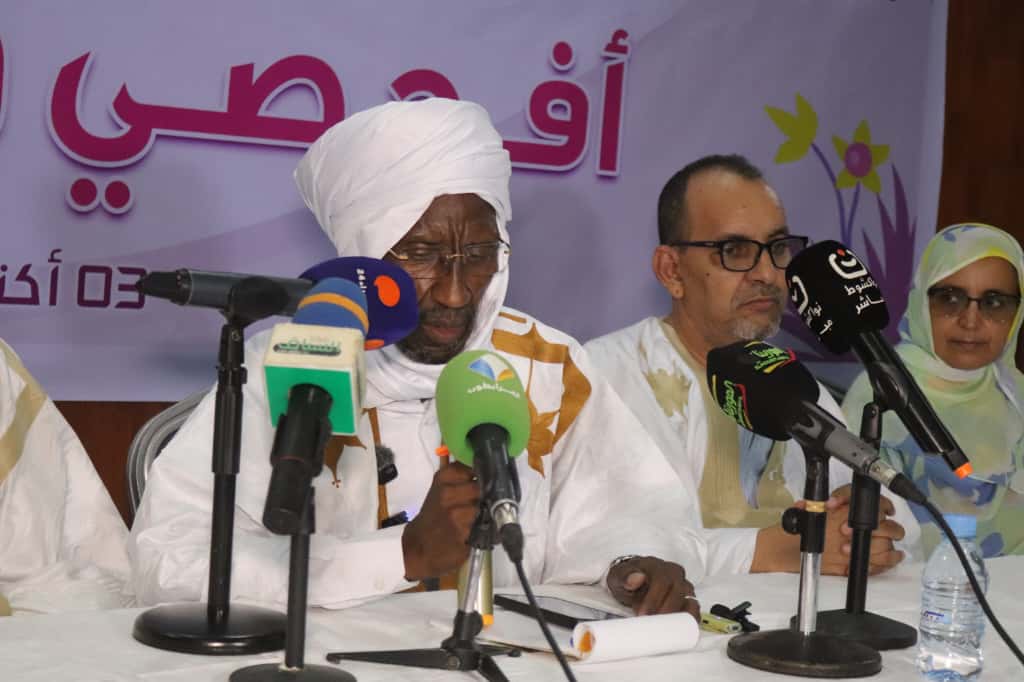 Speakers on the panel of an awareness event in front of a Pink October banner