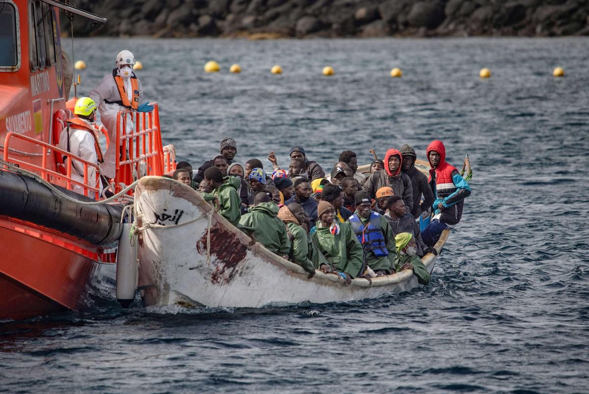A crowded migrant boat escorted by a Spanish rescue vessel