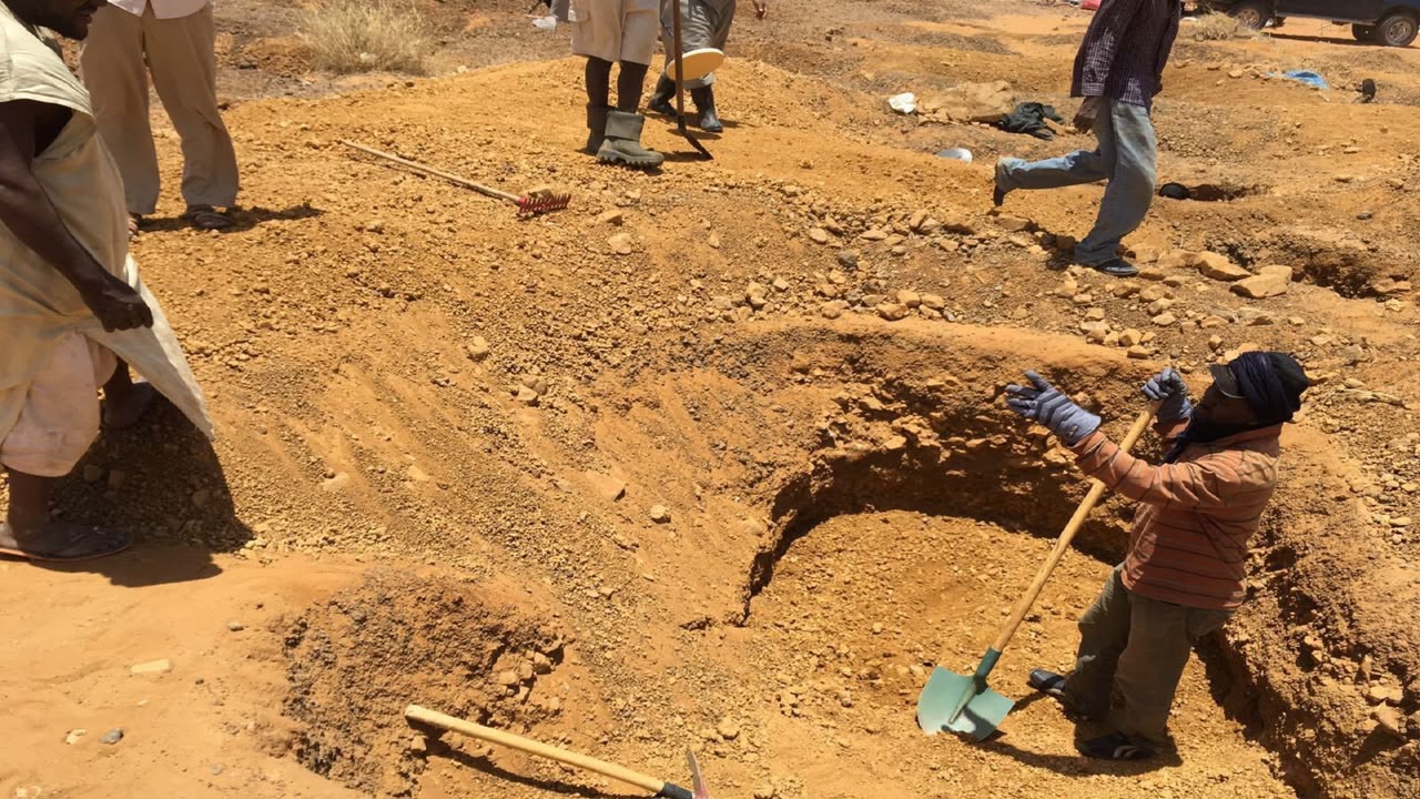 Gold miners digging in desert sand