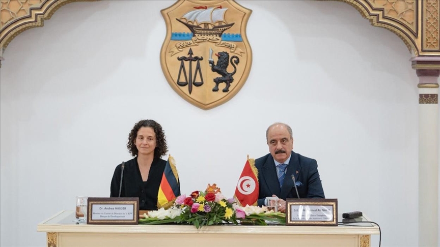 The emblem of the Tunisian Republic on a white wall behind an official table with Tunisian and German flags, file photo