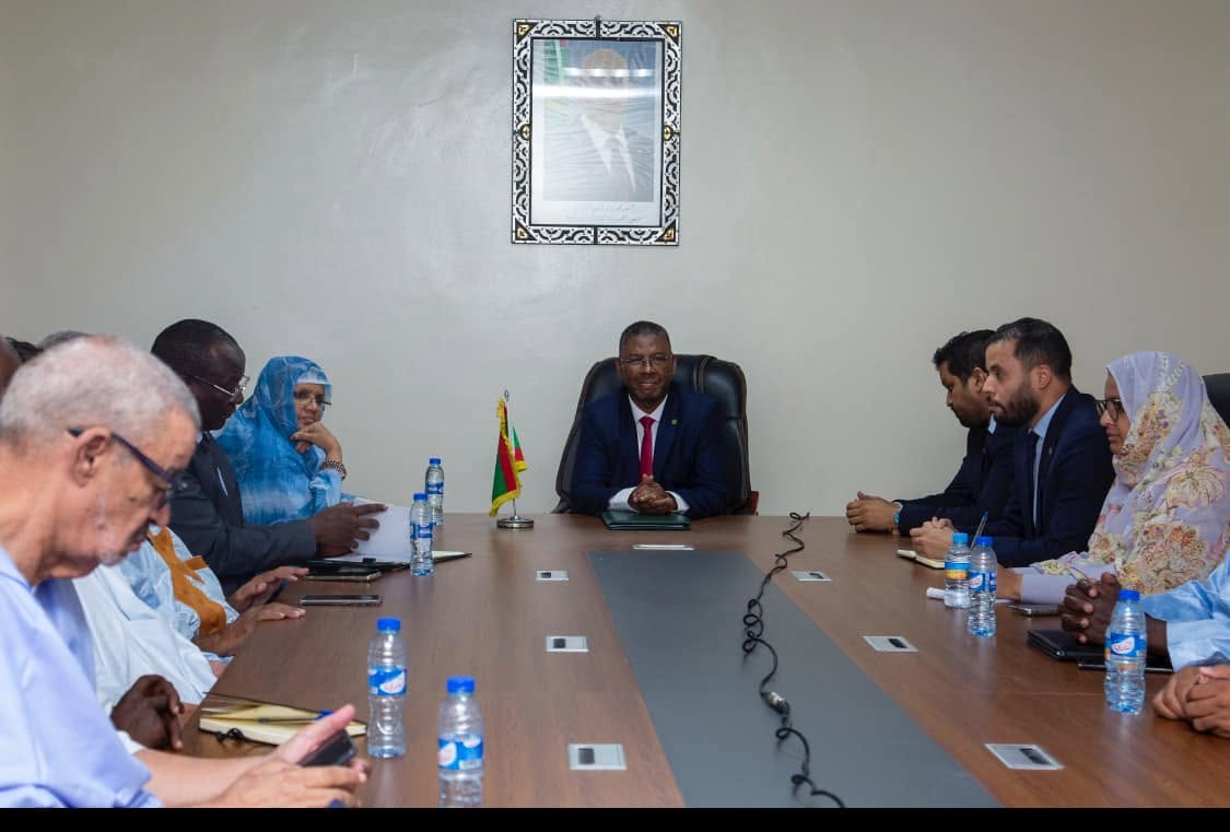 The minister delegate chairs a meeting at a table with mayors and regional officials