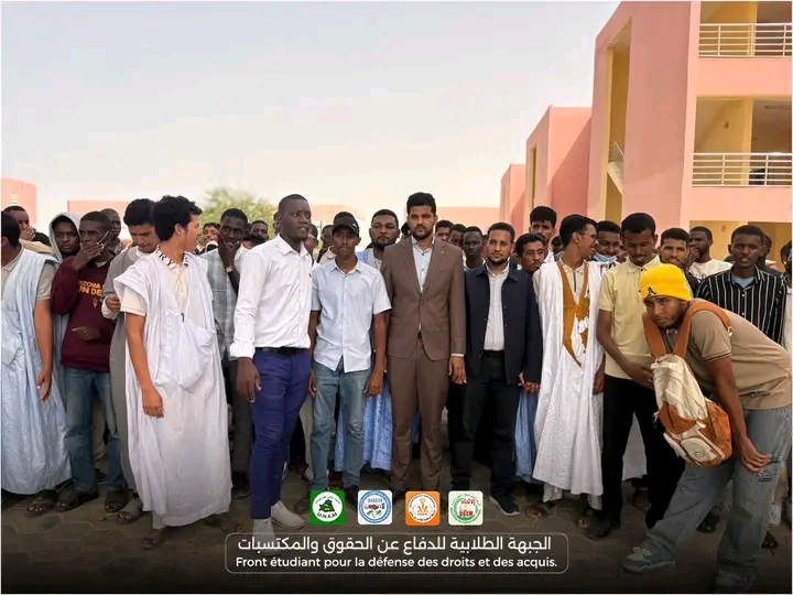 A group of students posing outside a university building
