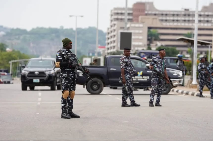Armed Nigerian police officers on a road in front of a police vehicle, file photo