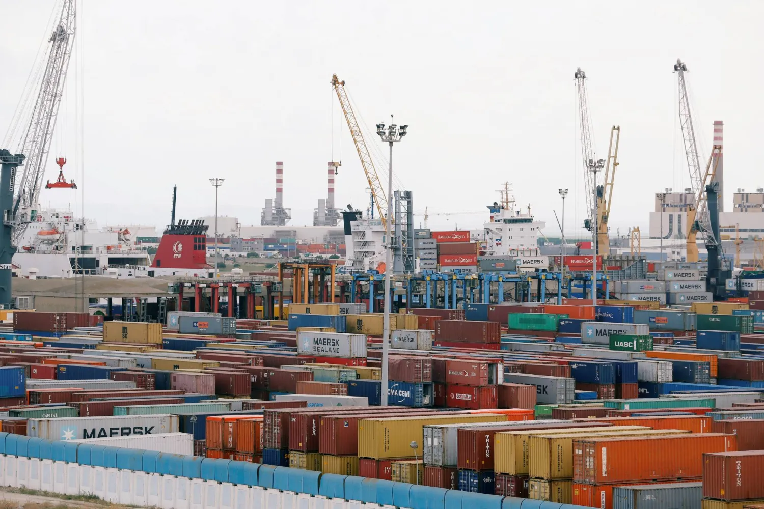 Rows of coloured containers, cranes and ships at a commercial port, file photo