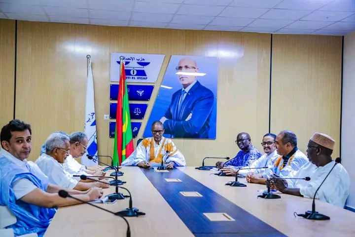 Officials seated around a table in a meeting room of the El Insaf party