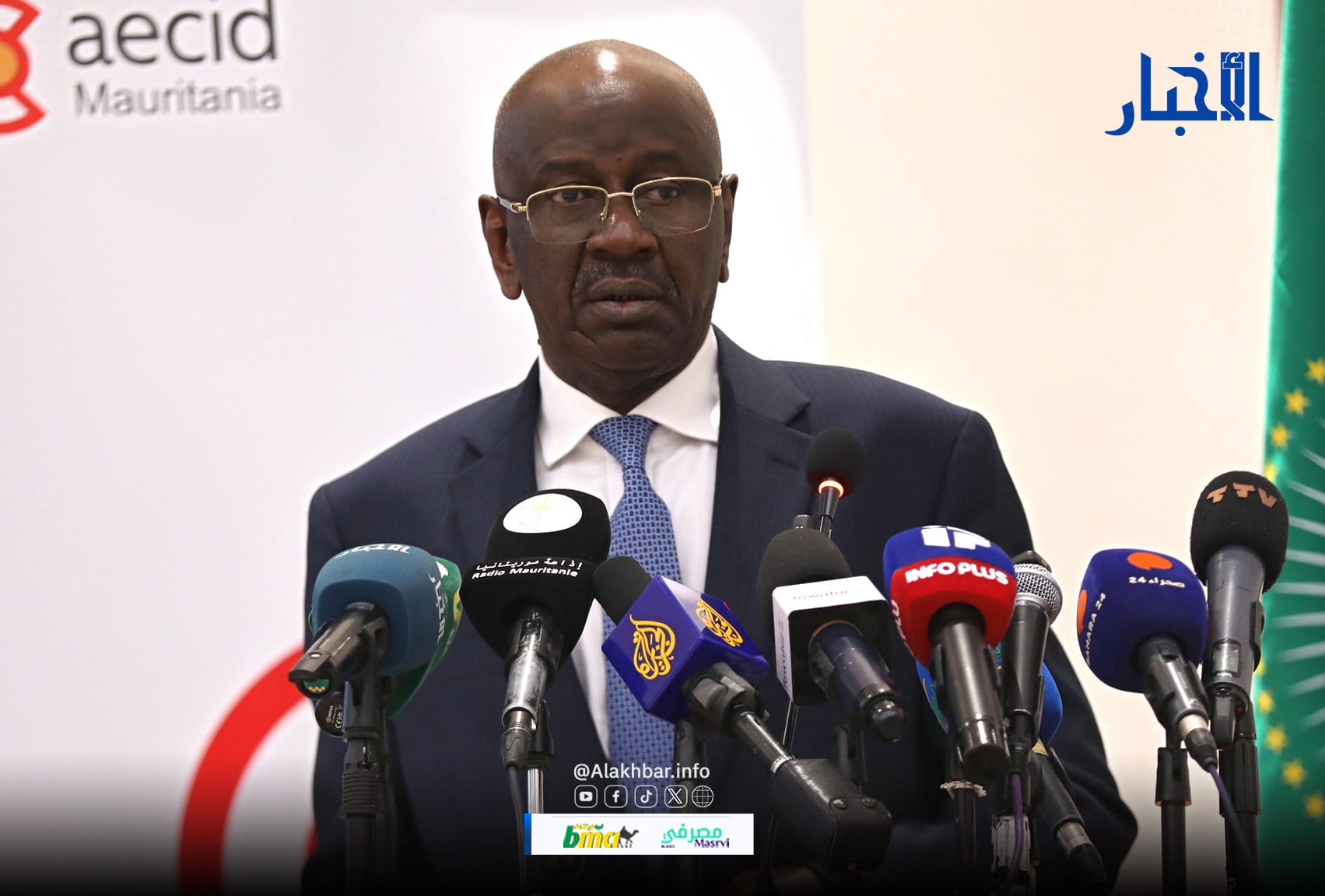 The foreign minister speaking in front of media microphones