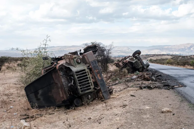 Burnt and overturned military vehicle wrecks by a road in a mountainous area of northern Ethiopia, file photo