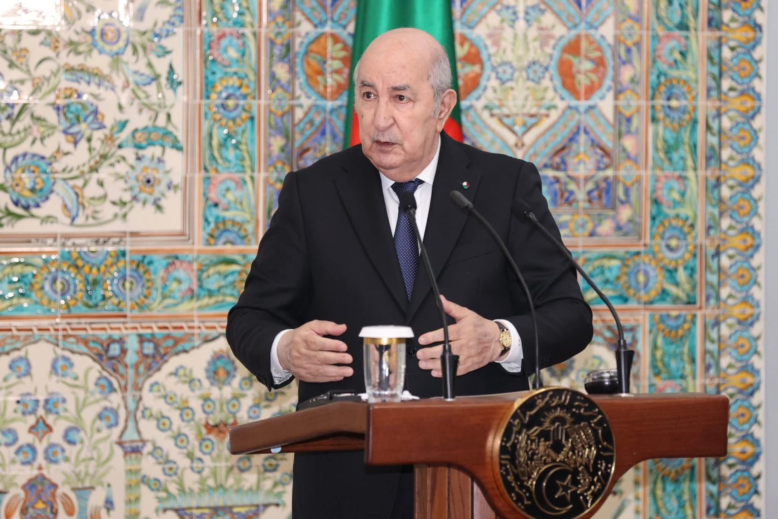 Algerian President Abdelmadjid Tebboune speaking at a lectern in front of a tiled wall, file photo