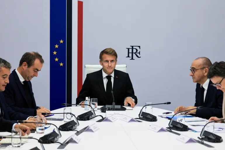 Emmanuel Macron chairing a meeting at a table with ministers