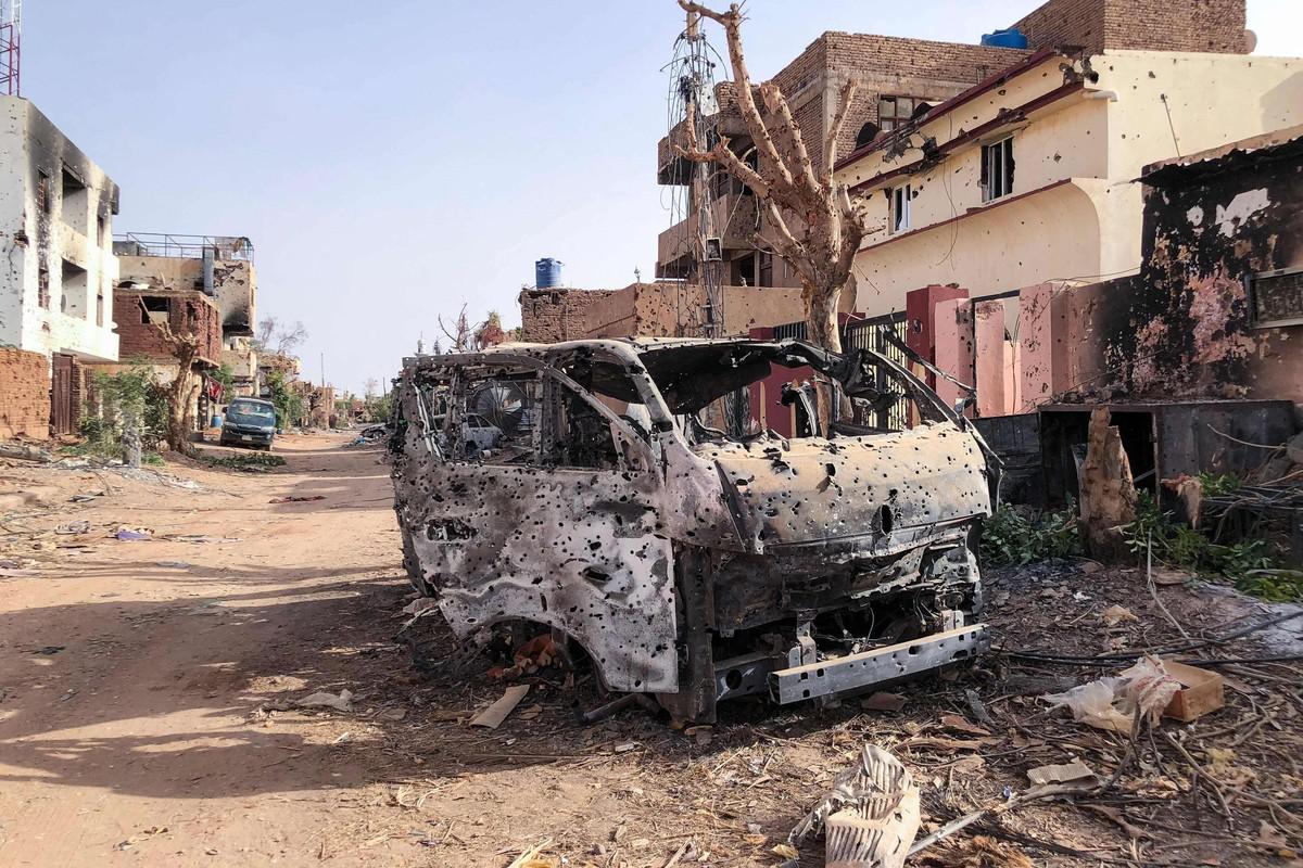 Burnt-out, bullet-riddled vehicle on a war-damaged street in Sudan, file photo