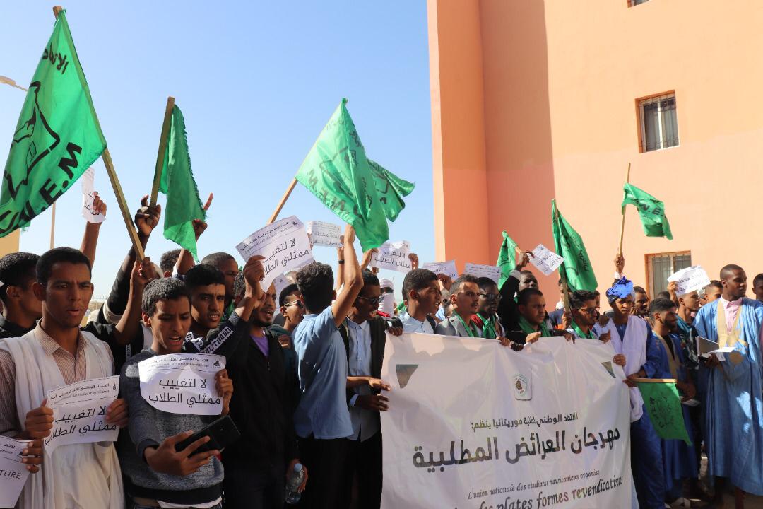 Students holding green flags and banners during a protest march in Nouakchott