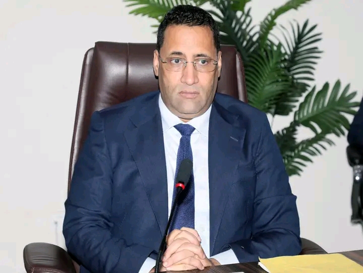 The prime minister seated at a desk with a microphone
