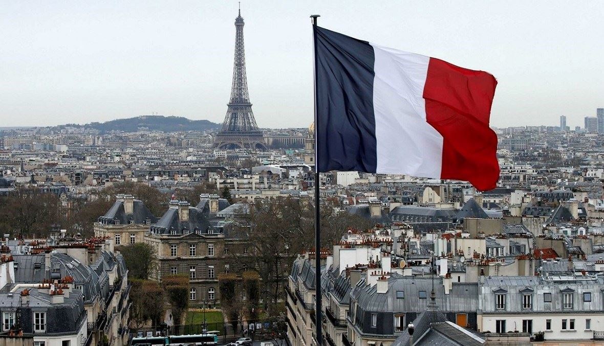 General view of Paris with the Eiffel Tower and a French flag in the foreground, file photo