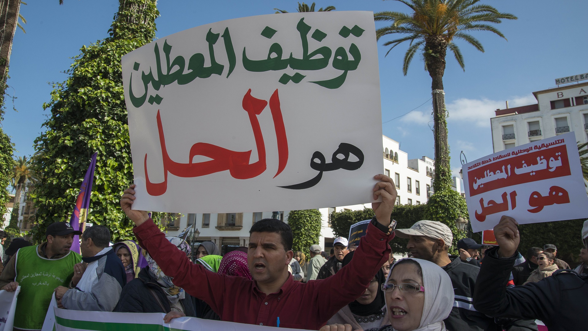 A protester holds up a sign calling for jobs for unemployed graduates during an earlier protest on Mohammed V Avenue in Rabat, file photo