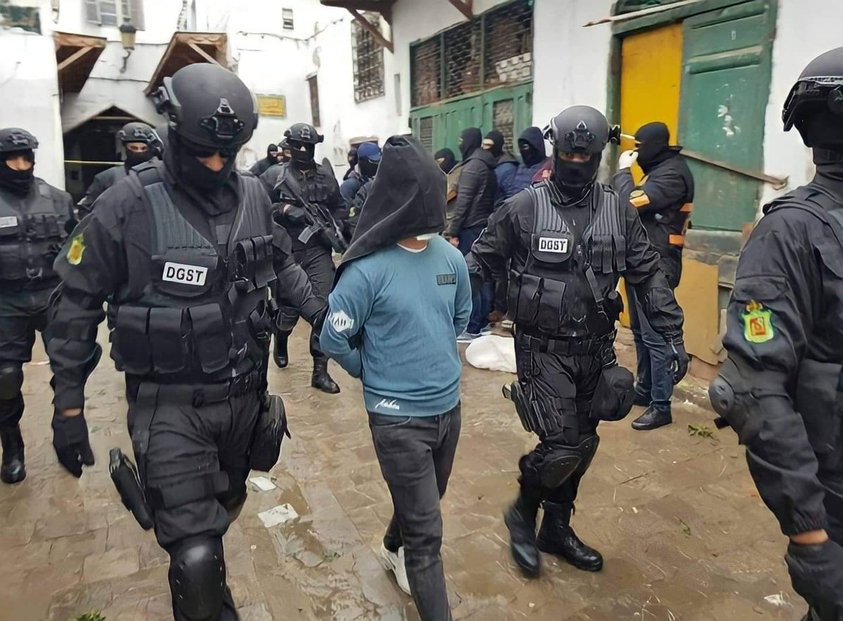 DGST officers escort a hooded suspect during an earlier security operation in Morocco
