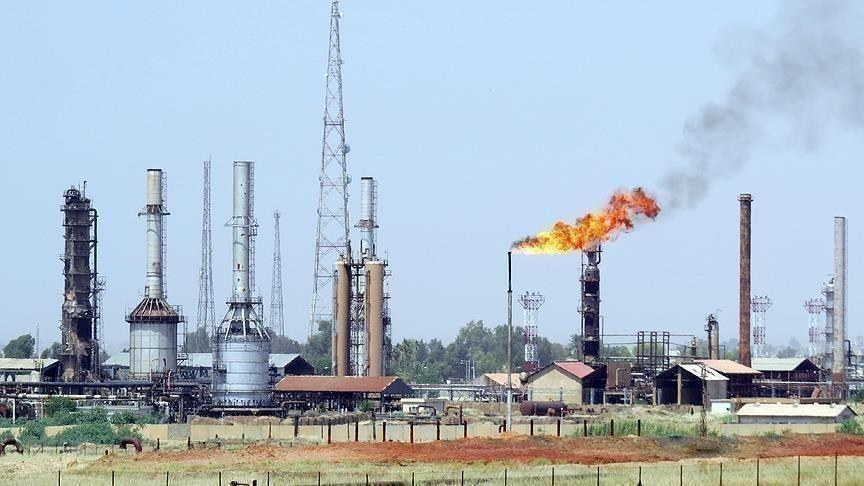 An oil facility with towers, tanks and a burning gas flare under a clear sky, illustrative file image