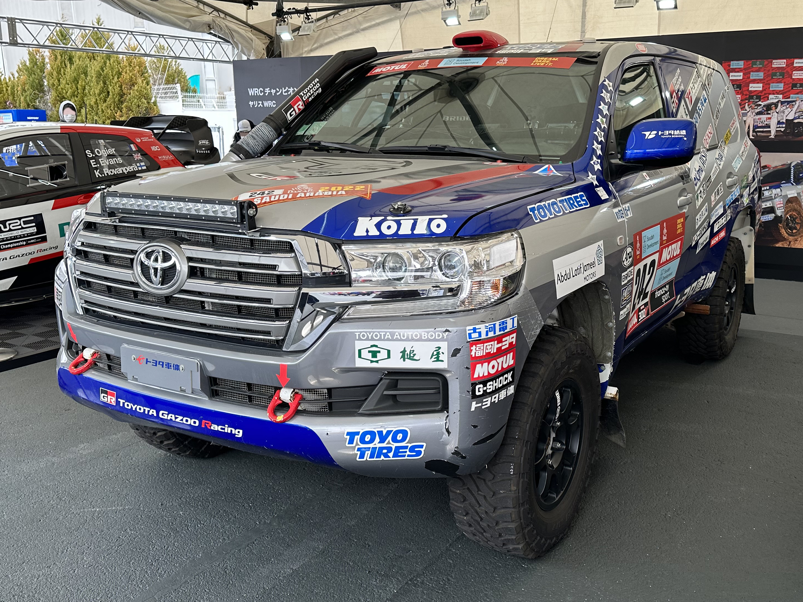 A Toyota Land Cruiser bearing 2022 Dakar Rally stickers on display at an exhibition