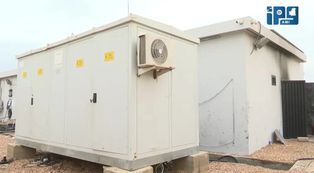An electrical cabin and a building blackened by soot at a transformer station in Nouakchott