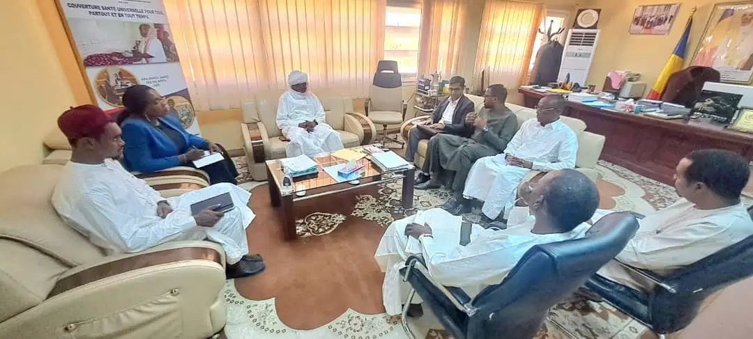 Officials seated in an office at Chad's health ministry, with the Chadian flag and a universal health coverage banner in the background, file photo