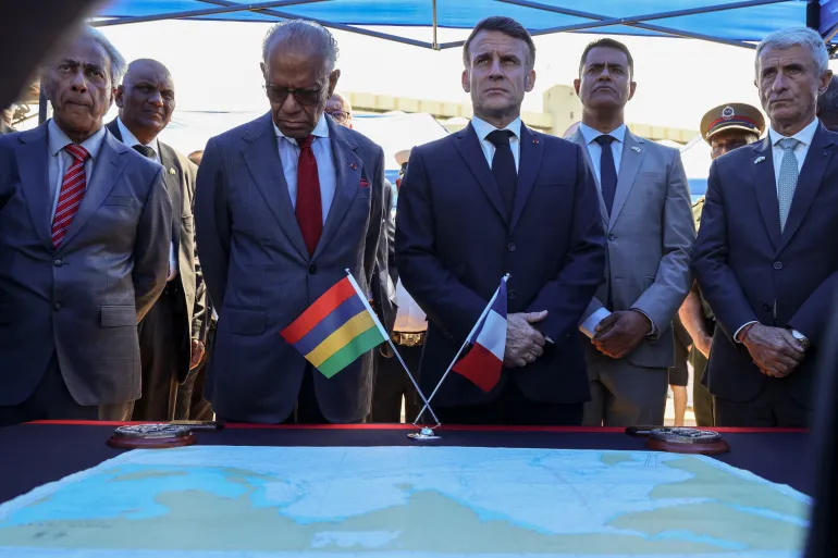 Mauritian and French officials standing at a table with the flags of Mauritius and France and a nautical chart, file photo