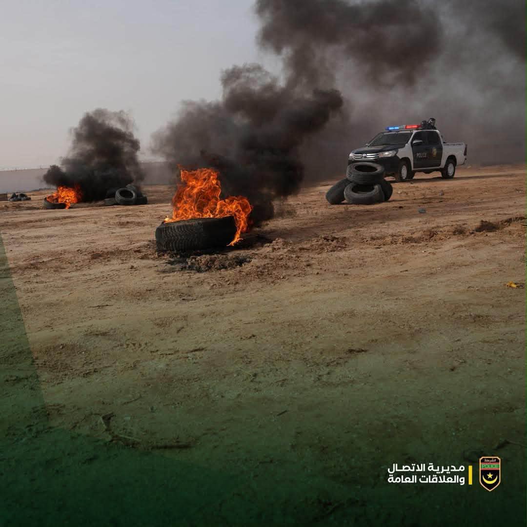 Burning tyres and a police vehicle during a field exercise