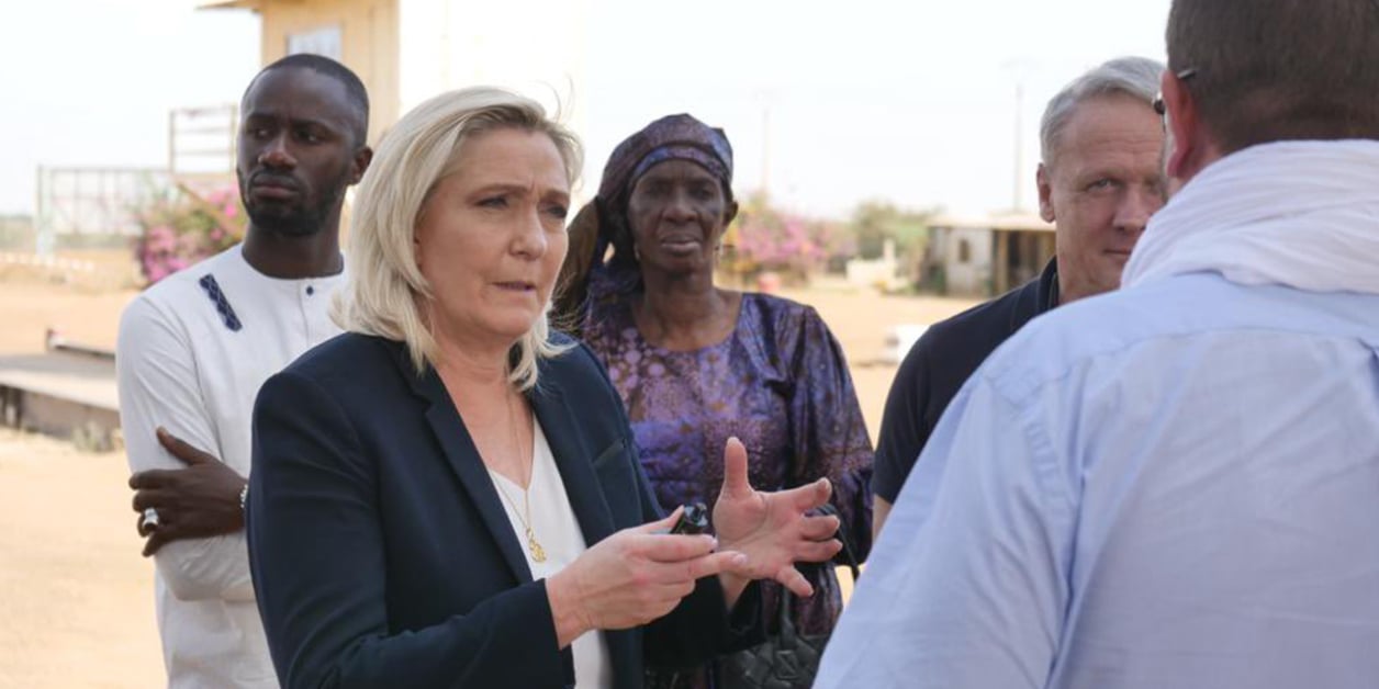 Marine Le Pen speaks outdoors with a group of people, file photo