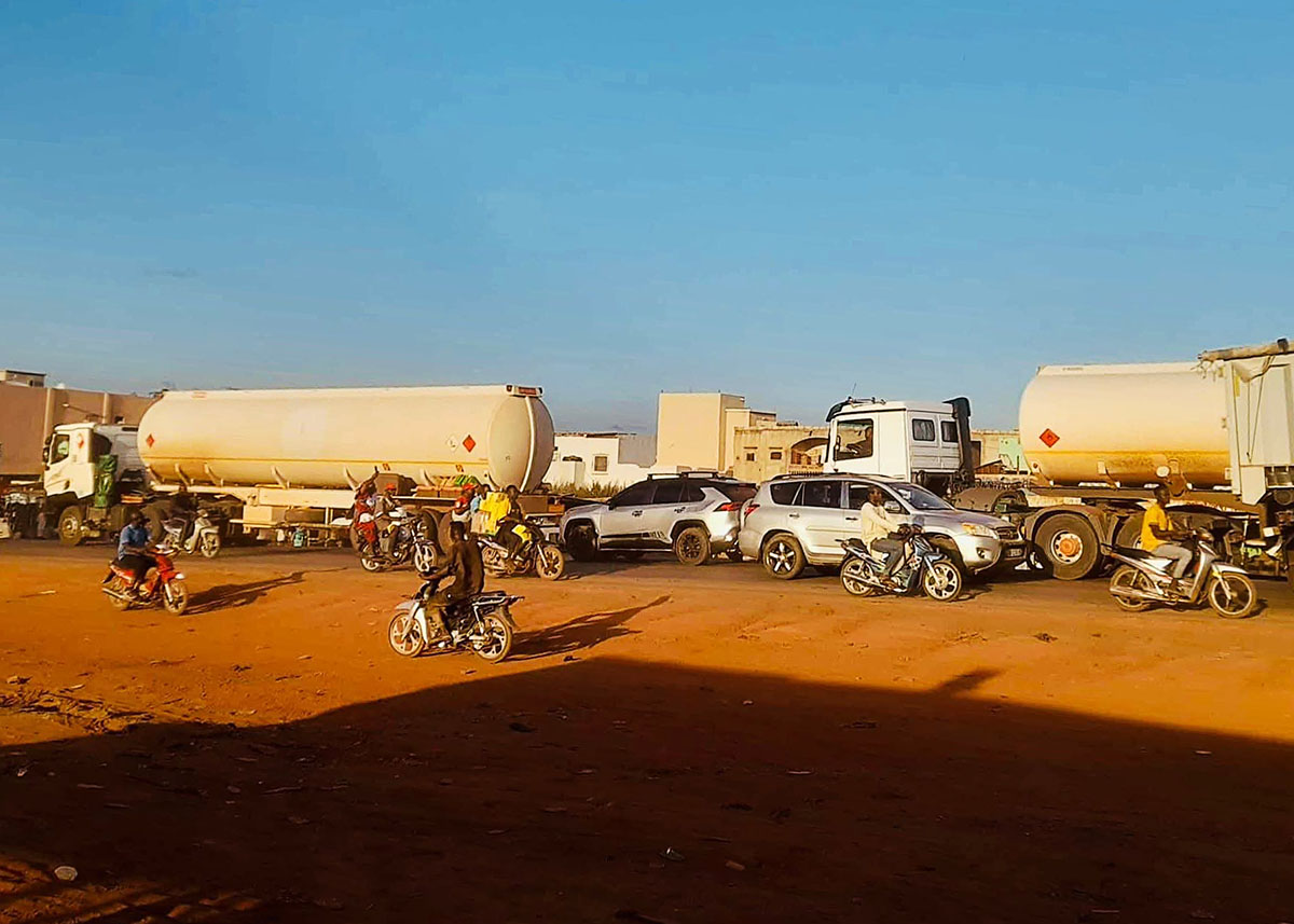Fuel tanker trucks, motorbikes and cars on a dirt road in Bamako, file photo