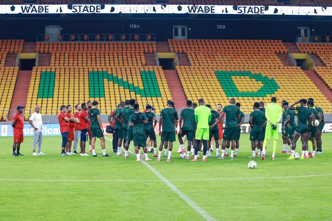Yellow and green stands at Abdoulaye Wade Stadium in Diamniadio with players gathered on the pitch during training, file photo